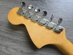 Fender Guitar tuning pegs on a wooden neck with a gray background