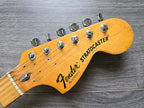 Fender Stratocaster guitar headstock on a wooden surface