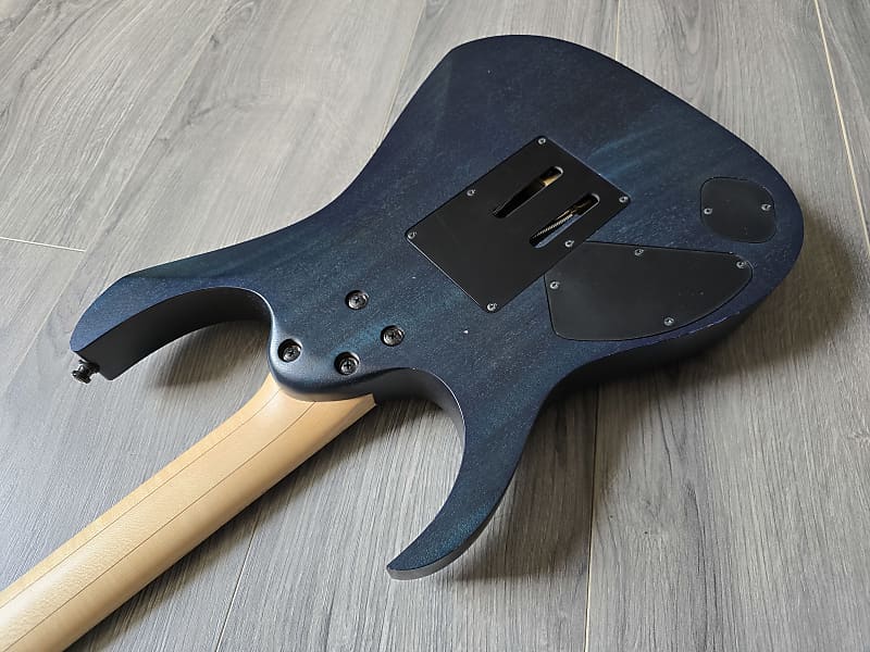 Blue electric guitar body on a wooden floor