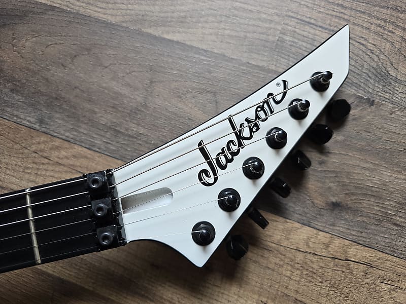 Jackson guitar headstock on a wooden surface