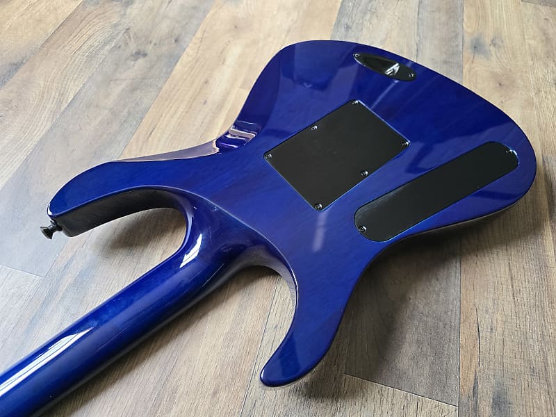 Back of blue guitar body on a wooden surface