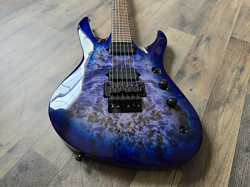 Blue marbled electric guitar displaying bridge and pickups on a wooden floor