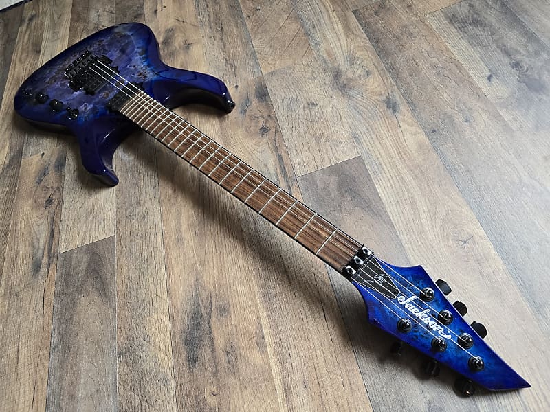 blue electric guitar neck and fretboard lying on wooden surface