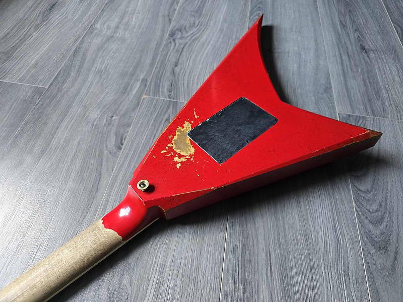 back of a red electric guitar body on a wooden surface