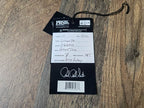 Product tag with 'PRS' branding on a wooden surface
