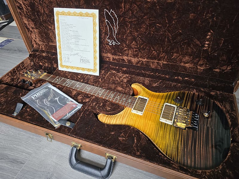 Glossy electric guitar in a brown case with a certificate inside