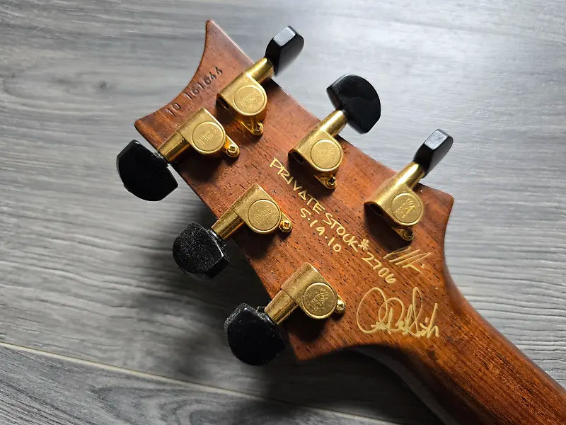 PRS private stock guitar headstock with tuning pegs on a wooden surface