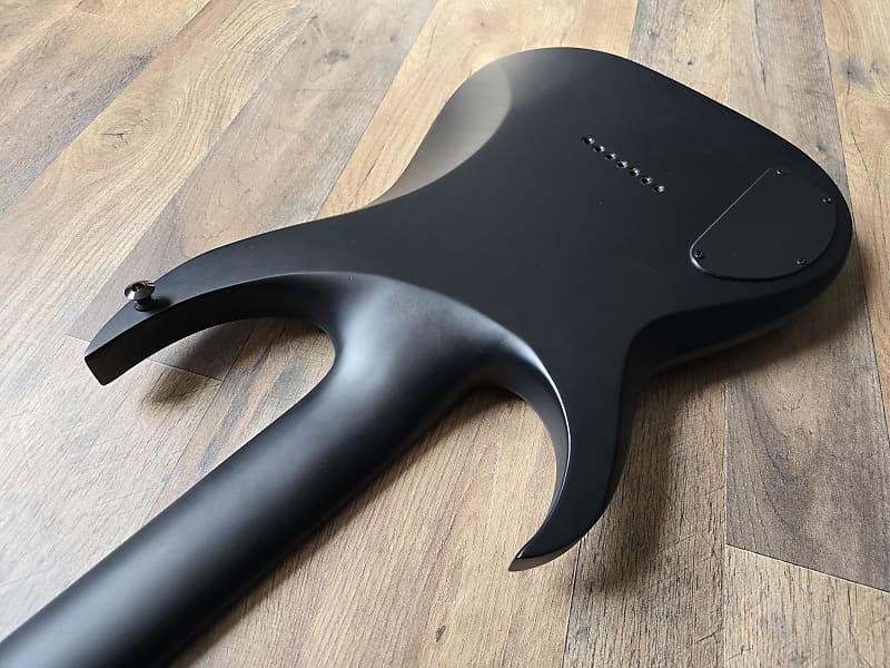 Black back side of electric guitar on  wooden surface background