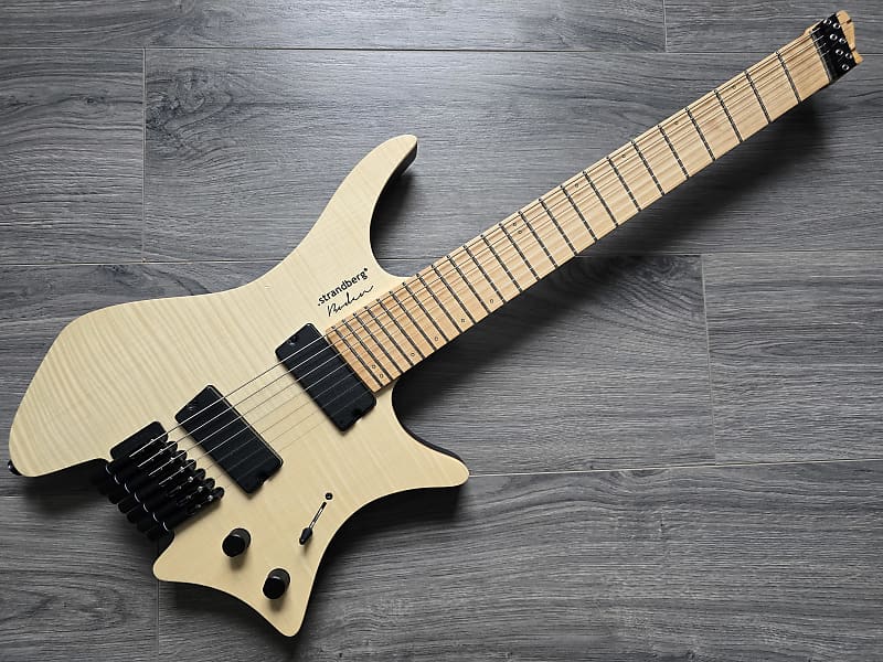 A Strandberg Guitars Boden Original NX 7 with a Swamp Ash body, 4A Quilted Maple top, Maple and Carbon Fiber neck, and Birdseye Maple Fretboard on a grey background.