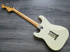 White Fender electric guitar lying face down on a gray wooden surface.
