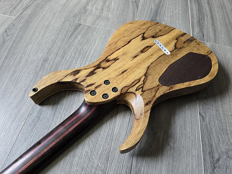 back of an electric guitar showing a wooden patterned body
