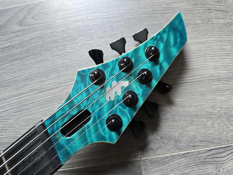 Turqoise guitar headstock featuring 'Vandermeij' branding and black tuning pegs